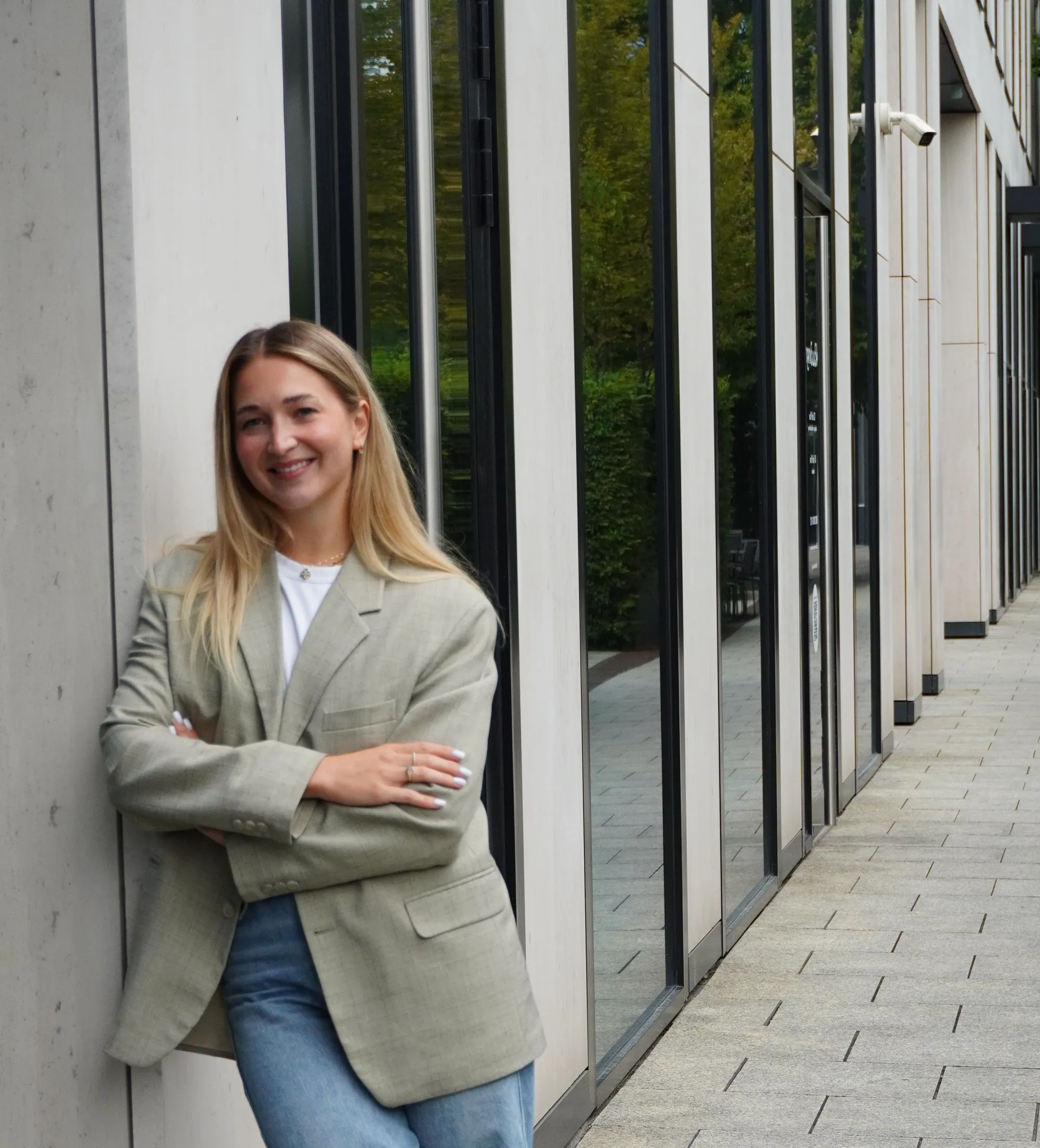 Monika Zielińska in a blazer, leaning against the wall of an office building